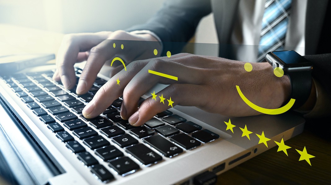 Persona che lavora su un laptop con simboli grafici che indicano un'esperienza utente positiva ed efficiente.
