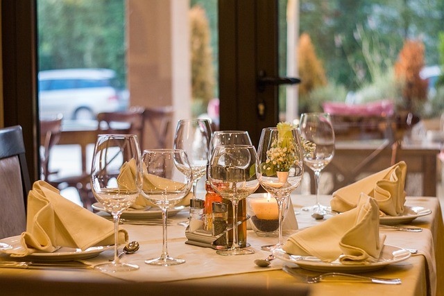 Tavolo elegantemente apparecchiato con bicchieri da vino e tovaglioli piegati in un raffinato ristorante.